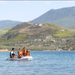 Family of four on Aqua Marina DELUXE boat on lake with mountains in background