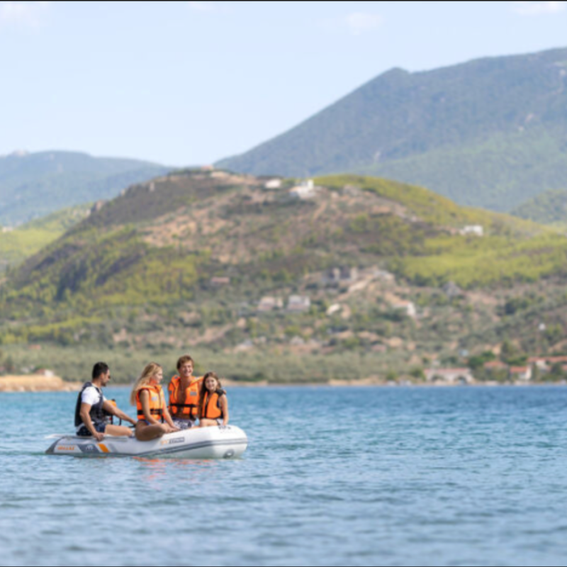 Family of four on Aqua Marina DELUXE boat on lake with mountains in background