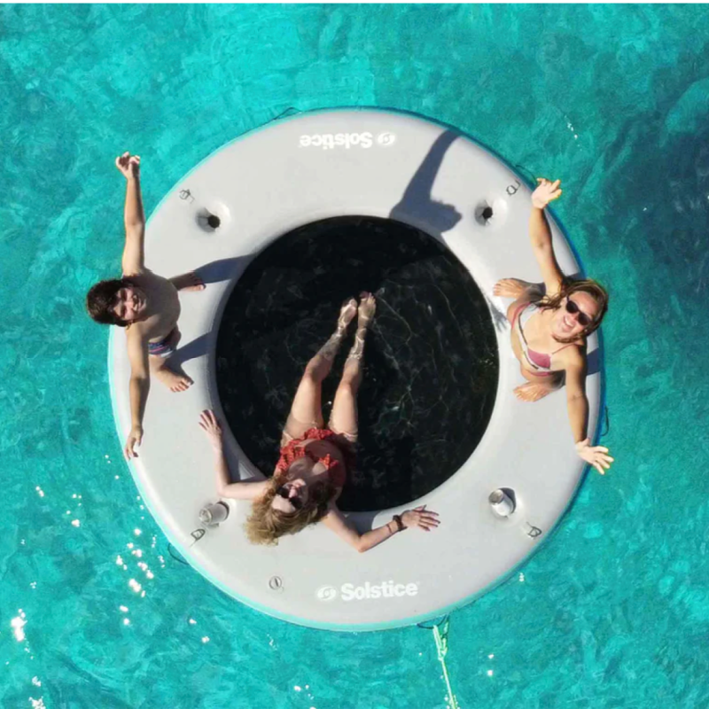 top view of 3 people enjoying Solstice Inflatable dock with mesh center for lounging