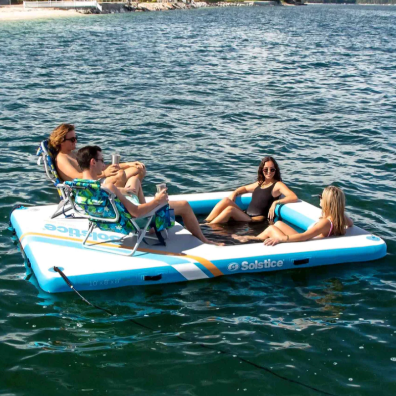 Four adults enjoying Solstice Inflatable Mess dock with insert