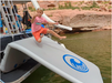 Young boy jumping onto his new Lakesurf-Slide Island inflatable Slide Dock Combo