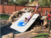 Children playing on Slide Island Inflatable Dock/Slide combo into swimming pool